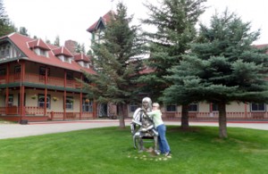 Person and statue outside a fancy inn.