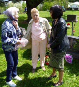 3 women taling to each other in the cemetary.