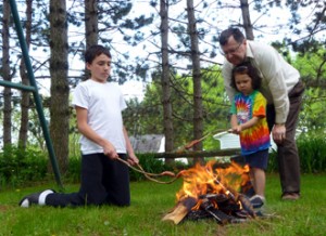 Family roasting hot dogs.