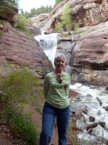 lady poses near a waterfall.