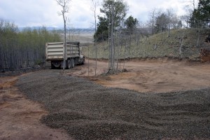 First truck finishes unloading. Note how uneven the gravel is spread