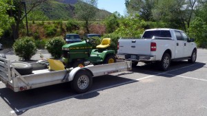 John Deere rider with blade on way to lot